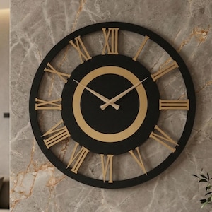 Può includere: Un grande orologio da parete circolare con una cornice esterna nera e un disco centrale nero circondato da un anello dorato. Il quadrante presenta numeri romani dorati e lancette sottili color oro, creando un design ad alto contrasto.