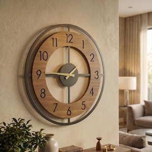 Puede incluir: Un reloj de pared grande y redondo con una esfera de madera y un marco de metal oscuro. El reloj presenta números negros y manecillas doradas. El reloj está montado en una pared beige, agregando un toque de encanto rústico a cualquier habitación.