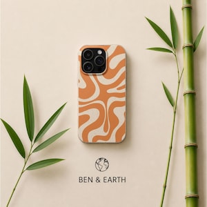 Puede incluir: Funda de teléfono con un diseño ondulado en naranja y crema. La funda está centrada sobre un fondo beige claro, con tallos y hojas de bambú verdes a ambos lados. El texto "BEN & EARTH" está en la parte inferior.