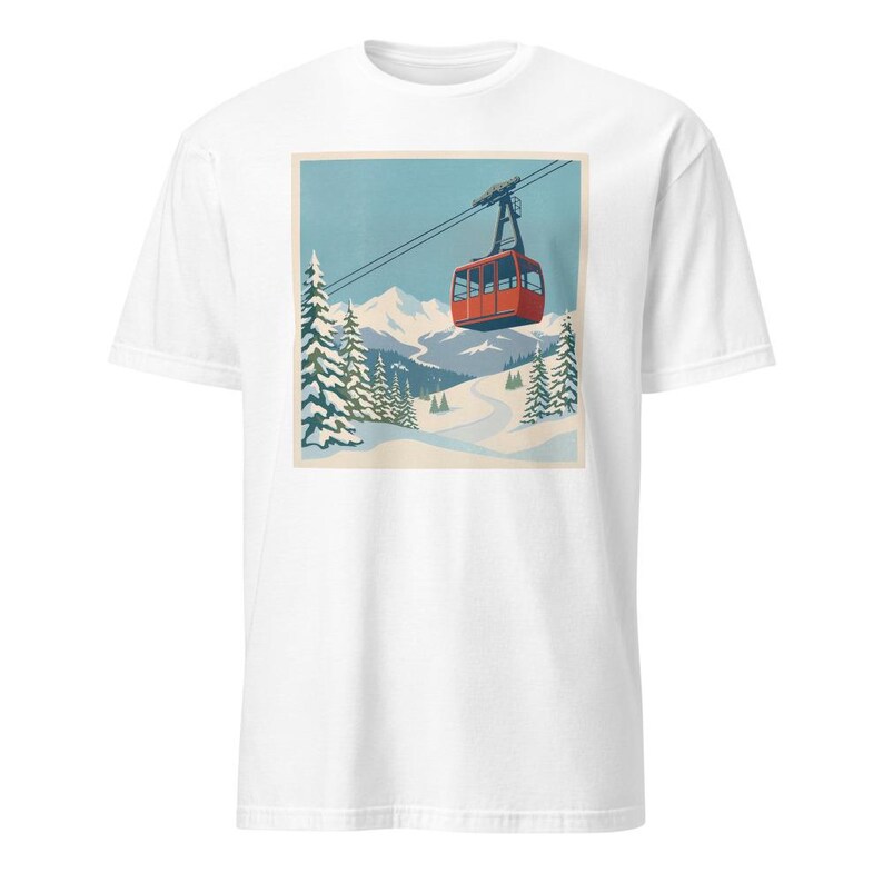 Puede incluir: Camiseta blanca con un estampado retro de un telef&eacute;rico rojo ascendiendo una escena de monta&ntilde;a nevada. El dise&ntilde;o incluye pinos, una pista de esqu&iacute; sinuosa y un cielo azul, que recuerda a un cartel de viaje vintage.