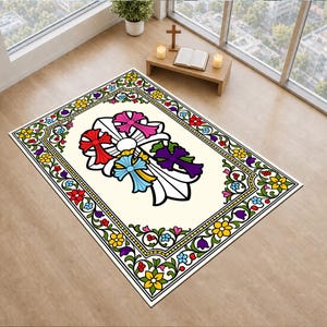 Puede incluir: Una alfombra rectangular con un centro de color crema y un gran gráfico de cruz estilizada en rojo, rosa, azul y morado. La alfombra está bordeada por un marco decorativo lleno de coloridos patrones florales en amarillo, rojo y morado.