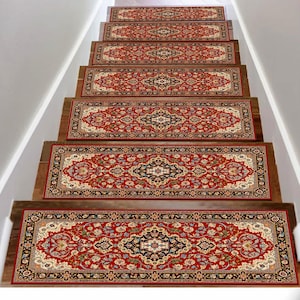 May include: A set of seven rectangular stair treads featuring a traditional red, cream, and black floral pattern with a central medallion design. Each tread is bordered by a dark frame and is installed on individual wooden stair steps.