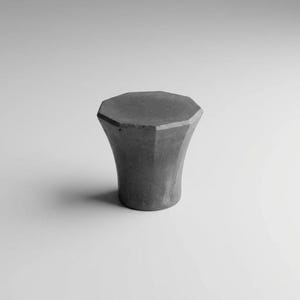 Può includere: Un tavolino in cemento grigio con piano ottagonale e base svasata. Il design moderno presenta una forma geometrica e una superficie liscia e strutturata. Il tavolo è adatto per uso interno o esterno.