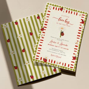 Op de afbeelding: Een rechthoekige uitnodiging voor een babyshower met bijpassende envelop, voorzien van een groen-wit gestreept patroon met lieveheersbeestjes en witte bloemen. De tekst luidt A LITTLE love bug IS ON THE WAY, Amelia & Alexander, MONDAY, SEP 7TH, AT 1:00 PM.