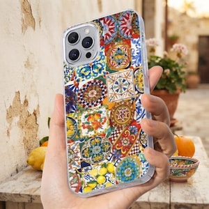 Può includere: Una cover trasparente per smartphone con un vivace collage di motivi di piastrelle in ceramica in stile mediterraneo, inclusi disegni circolari, motivi floreali e illustrazioni di limoni gialli, con un'apertura per la tripla fotocamera.