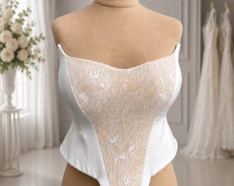 Corset made of dense milk satin. Duplicated on grommets. Decorated with lace with sequins.