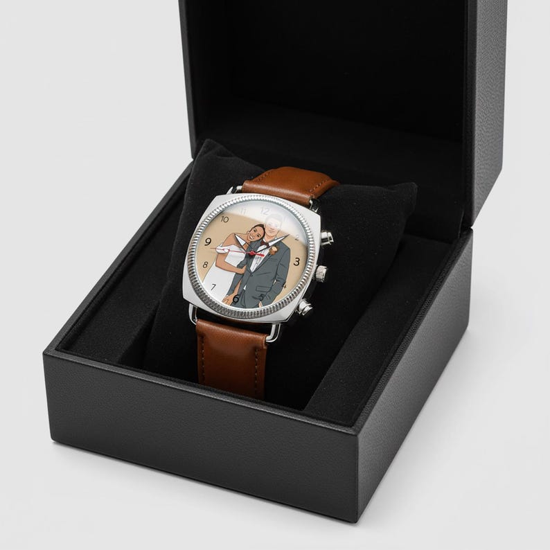 May include: A square-faced wristwatch with a brown leather strap, presented in a black box. The watch face displays a couple in formal wear. The watch has silver accents and a brown leather strap.