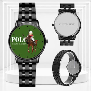 May include: A black metal wristwatch with a green face featuring a Polo Ralph Lauren bear graphic and text. The watch includes a matching black link band. A second view shows the back of the watch casing with the text CUSTOM TEXT engraved.