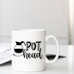 May include: White ceramic coffee mug with a black graphic of a coffee pot and the text "POT head".