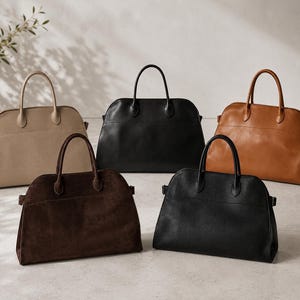 May include: Five leather handbags in different colours: beige, black, dark brown, and tan. Each bag has a structured shape with a top handle and a rectangular silhouette. The bags are displayed on a neutral surface.