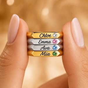 Pode incluir: Quatro anéis personalizados com os nomes Chloe, Emma, Ava e Mia. Cada anel tem uma pedra preciosa de cor diferente. Os anéis são de cor ouro e prata.