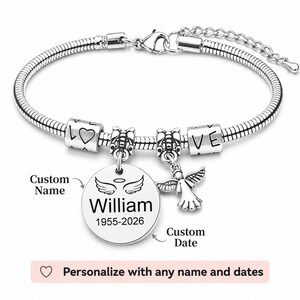 May include: A silver bracelet with a snake chain. It has charms spelling "LOVE", a heart, and an angel pendant. A round charm is engraved with the name "William" and dates "1955-2026".