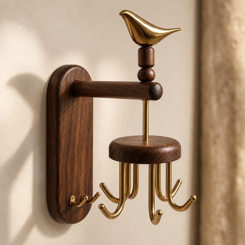 May include: A wall-mounted hook rack featuring a dark brown wooden base with two small hooks and a horizontal arm supporting a rotating circular wooden platform. This platform holds six gold-toned metal hooks, topped by a gold-toned bird figurine.