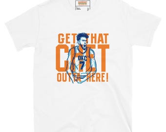 May include: A white short-sleeve t-shirt featuring a graphic of a basketball player in an OKC jersey with the number 7. The text GET THAT OUTTA HERE! is printed in large orange letters around the illustration. A Gameday label is at the neck.