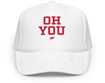 May include: A white trucker hat featuring a structured front panel and a mesh back. The front displays the red text "OH YOU" in a bold, block-style font, positioned above a small, stylized red graphic icon.