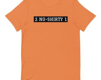 May include: A short-sleeved orange t-shirt featuring a black rectangular graphic on the chest. Inside the black rectangle, the white text reads 2 NO-SHIRTY 1 in a bold, sans-serif font. The shirt has a crew neckline and a standard fit.