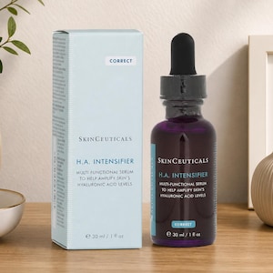 SkinCeuticals H.A. Intensifier serum bottle and box displayed on a wooden table with minimal home decor and neutral wall background