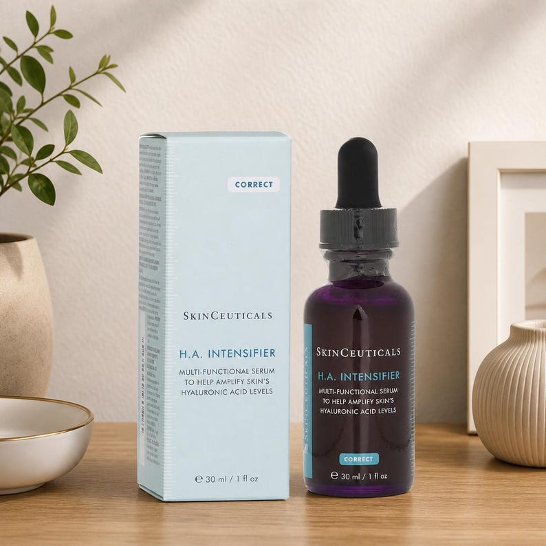 SkinCeuticals H.A. Intensifier serum bottle and box displayed on a wooden table with minimal home decor and neutral wall background
