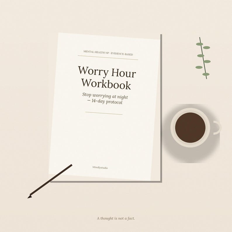 Puede incluir: Un cuaderno de ejercicios color crema titulado Worry Hour Workbook con el subt&iacute;tulo Stop worrying at night - 14-day protocol. La portada incluye el texto Mental Health NP - Evidence-Based y Mindlystudio. Un bol&iacute;grafo negro y caf&eacute; est&aacute;n cerca.