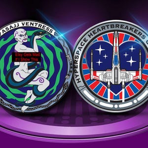 May include: Two round, colorful coins. One features a woman with a snake, the text "Asajj Ventress", and the text "Etsy Gets Mad If I Show This". The other coin has a spaceship design and the text "Hyperspace Heartbreakers Collection".