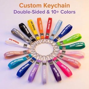 Könnte beinhalten: Eine Sammlung farbenfroher, doppelseitiger, individueller Schlüsselanhänger. Jeder Schlüsselanhänger hat einen Riemen in einer anderen Farbe, auf dem der Text "Custom Text", "Custom Front Text" oder "Custom Back Text" aufgedruckt ist. Das Bild enthält auch den Text "Custom Keychain Double-Sided & 10+ Colors".