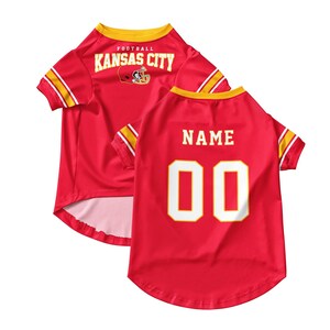 May include: Red pet jersey with yellow and white accents. The jersey features the text "KANSAS CITY" and a football helmet graphic on the back. The number "00" is displayed on the back, with space for a name.