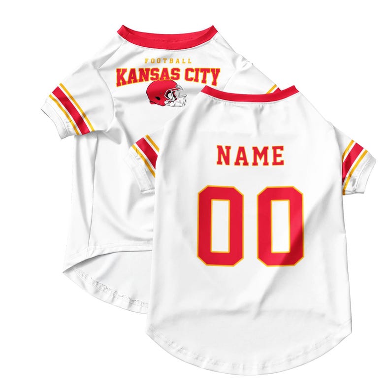 May include: White pet jersey with red and gold accents. The front features "FOOTBALL KANSAS CITY" and a helmet graphic. The back displays "NAME" above the number "00" in red with a gold outline. The sleeves have red and gold stripes.