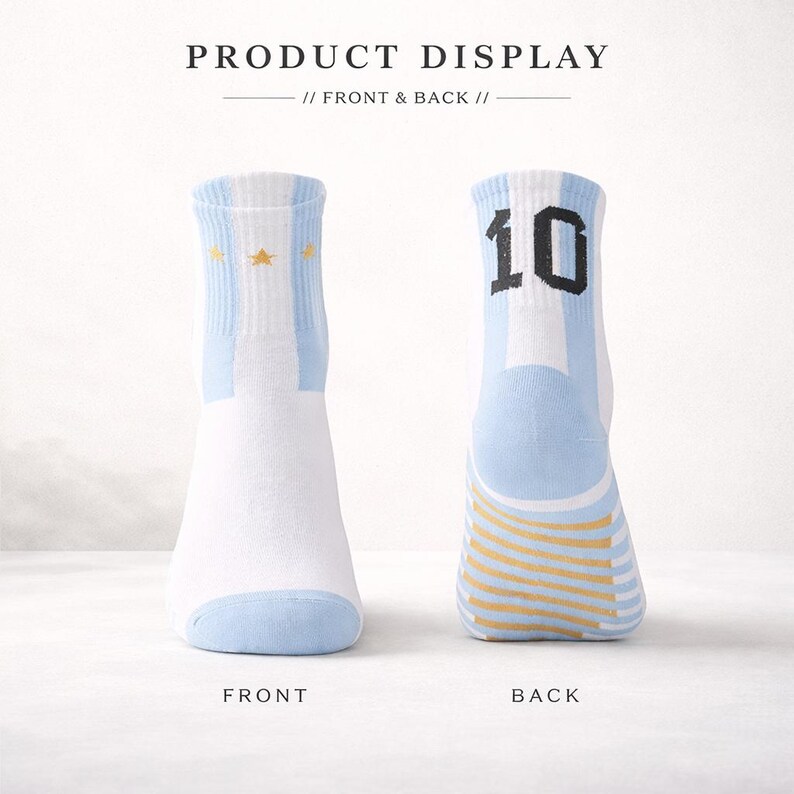 Puede incluir: Par de calcetines blancos y celeste con detalles de estrellas doradas y el n&uacute;mero 10 en la parte trasera. Los calcetines tienen un dise&ntilde;o a rayas y est&aacute;n etiquetados "FRONT" y "BACK". El texto "PRODUCT DISPLAY // FRONT & BACK //" est&aacute; en la parte superior.