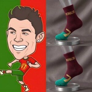 Peut inclure: L'image pr&eacute;sente une illustration de dessin anim&eacute; d'un joueur de football en uniforme rouge et vert, ainsi que deux paires de chaussettes marron. Les chaussettes portent le nom "RONALDO" avec des accents turquoise et dor&eacute;s.