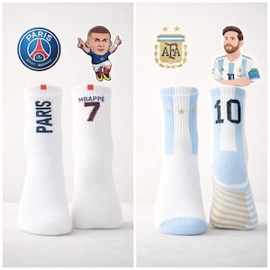 Puede incluir: Calcetines deportivos blancos con logotipos de equipos e ilustraciones de jugadores. Un par presenta "PARIS" y "MBAPPE 7". El otro par tiene un dise&ntilde;o de bandera argentina y el n&uacute;mero "10".