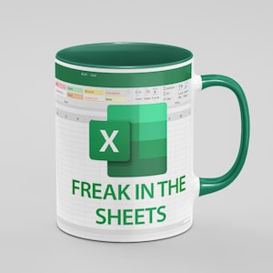 May include: White ceramic mug with a green interior and handle. The mug features an Excel spreadsheet design with the Microsoft Excel logo and the text "FREAK IN THE SHEETS" in green letters.