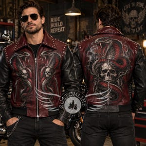 May include: A burgundy and black leather jacket featuring silver stud detailing on the collar and shoulders. The front and back display a detailed graphic print of a coiled red cobra snake with its mouth open, positioned above a human skull.