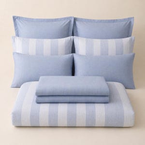 May include: A light blue and white striped bedding set. The set includes several pillowcases, a duvet cover, and a fitted sheet. The pillowcases are solid light blue, while the duvet cover and fitted sheet have vertical white stripes.