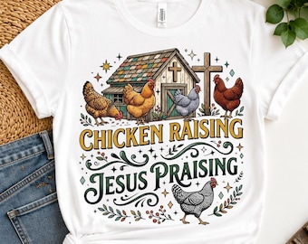 Pode incluir: Uma t-shirt branca com um gráfico de um celeiro, uma cruz e cinco galinhas de várias cores. O texto diz CHICKEN RAISING e JESUS PRAISING em letras estilizadas, rodeado por ornamentos decorativos, estrelas e pequenos detalhes de folhas.