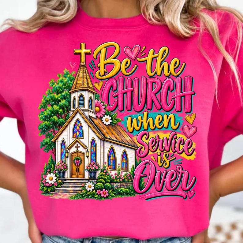 Pode incluir: Uma camisola cor-de-rosa brilhante com uma ilustra&ccedil;&atilde;o gr&aacute;fica de uma igreja com vitrais, rodeada por &aacute;rvores verdes e flores coloridas. O texto diz Be the CHURCH when Service is Over em letras amarelas e cor-de-rosa.
