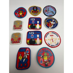 Könnte beinhalten: Eine Sammlung von Vintage-Bowling-Patches in verschiedenen Formen. Die Patches zeigen Bowlingkegel, Bowlingkugeln und Zeichentrickfiguren. Zu den Farben gehören Rot, Blau, Gelb und Weiß. Einige Patches haben Text wie "125 Games" und "Greater Springfield YABA".