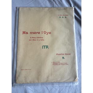 Könnte beinhalten: Ein Vintage-Notenblatt-Cover für "Ma mère l'Oye" von Maurice Ravel, mit Text in Rot und Schwarz. Das Cover befindet sich in einer transparenten Plastikhülle. Titel und Name des Komponisten sind deutlich sichtbar.