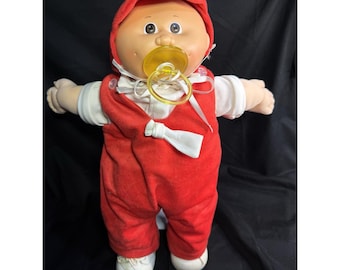 Bambola vintage Cabbage Patch Kids con vestito rosso, ciuccio e occhi marroni, marca Coleco, 1982