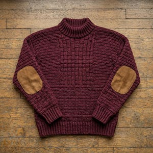 Könnte beinhalten: Ein tiefburgunderfarbener Strickpullover mit hohem Stehkragen, langen Ärmeln und einem zentralen vertikalen Paneel mit geflochtener Textur. Der Pullover verfügt über hellbraune Wildleder-Ellbogenpatches an beiden Ärmeln sowie gerippte Bündchen.