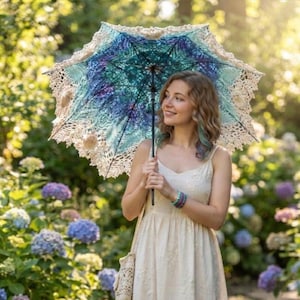 May include: A parasol featuring a circular canopy with a gradient of blue and purple hues, finished with an intricate cream-colored crocheted lace border and a central black handle, held upright to display the detailed textile craftsmanship.