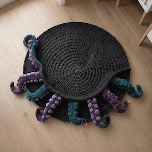 May include: A round, dark gray crocheted rug featuring several three-dimensional octopus tentacles extending from underneath the edges. The tentacles are textured with raised circular suckers and colored in alternating shades of purple and teal.