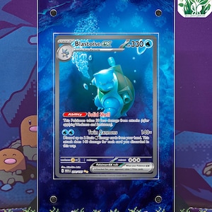 May include: A framed Pokémon Blastoise EX trading card. The card features a blue Blastoise character with the text "Blastoise EX" and "Twin Cannons". The card is displayed against a blue and purple background. The text "Card does not come with case" is at the top and bottom.