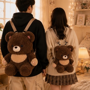 Pode incluir: Duas mochilas de pelúcia em forma de urso com pelo castanho escuro, uma mancha bege clara na barriga, orelhas redondas com detalhes cor-de-rosa e olhos de plástico preto. Cada mochila tem alças bege ajustáveis presas nas costas do urso.