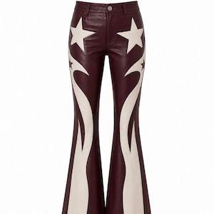 May include: Dark burgundy leather pants featuring a flared leg silhouette. The pants are decorated with large, cream-colored star appliques on the upper thighs and long, flame-like cream-colored panels extending down the outer legs to the hem.
