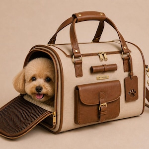 May include: Tan and brown pet carrier with a small dog peeking out. The carrier has a zippered front opening, brown leather accents, a handle, and a shoulder strap. A brown dog bed is visible inside the carrier.
