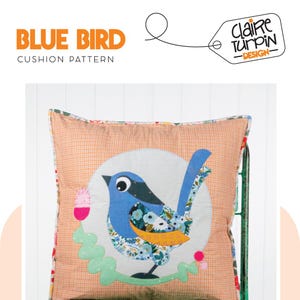 Può includere: Un modello di cuscino con un uccello blu con un design a patchwork. L'uccello è circondato da foglie verdi e fiori rosa. Il cuscino è fatto di un tessuto arancione chiaro con un motivo a scacchi. Il testo "BLUE BIRD CUSHION PATTERN" è nella parte superiore dell'immagine. Il testo "Claire Turpin - DESIGN" è su un'etichetta nella parte superiore destra dell'immagine.