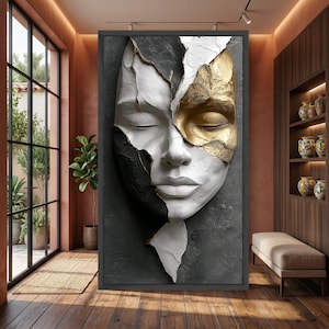 May include: A rectangular wall art piece featuring a sculpted human face with closed eyes. The face is divided into sections of matte white, textured black, and metallic gold leaf, set against a dark gray, rough-textured background surface.