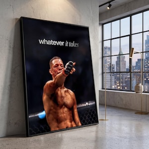 Puede incluir: Un cuadro rectangular enmarcado que muestra a un luchador sin camisa con sangre en la cara y el pecho, usando un guante negro y señalando hacia adelante. El fondo es oscuro y el texto blanco "whatever it takes" está impreso en la parte superior.