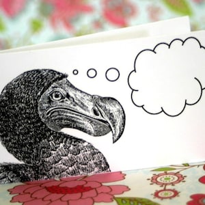 May include: A black and white illustration of a dodo bird with a thought bubble above its head. The dodo is looking to the right and has a serious expression on its face.