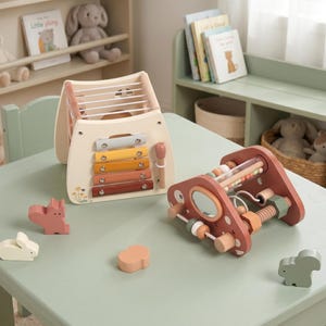 May include: A wooden xylophone with colorful bars and a mallet, alongside a wooden abacus-style toy and several wooden animal figures, all on a light green table. The toys are designed for early childhood development.